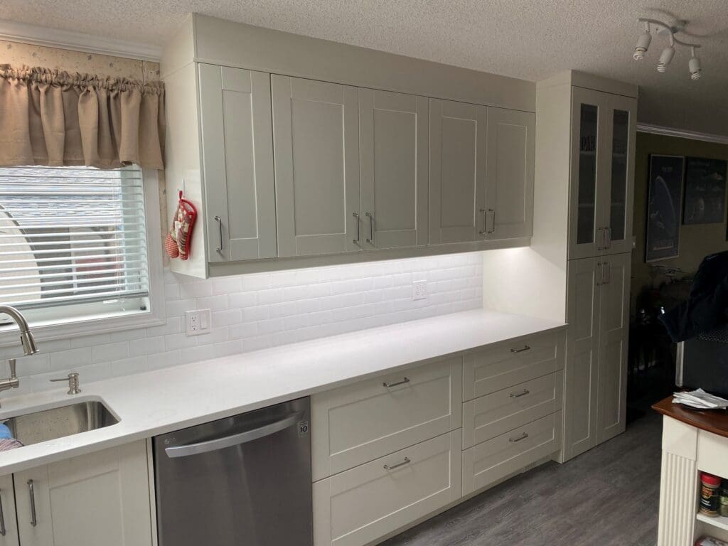 A kitchen with white cabinets and a dishwasher.