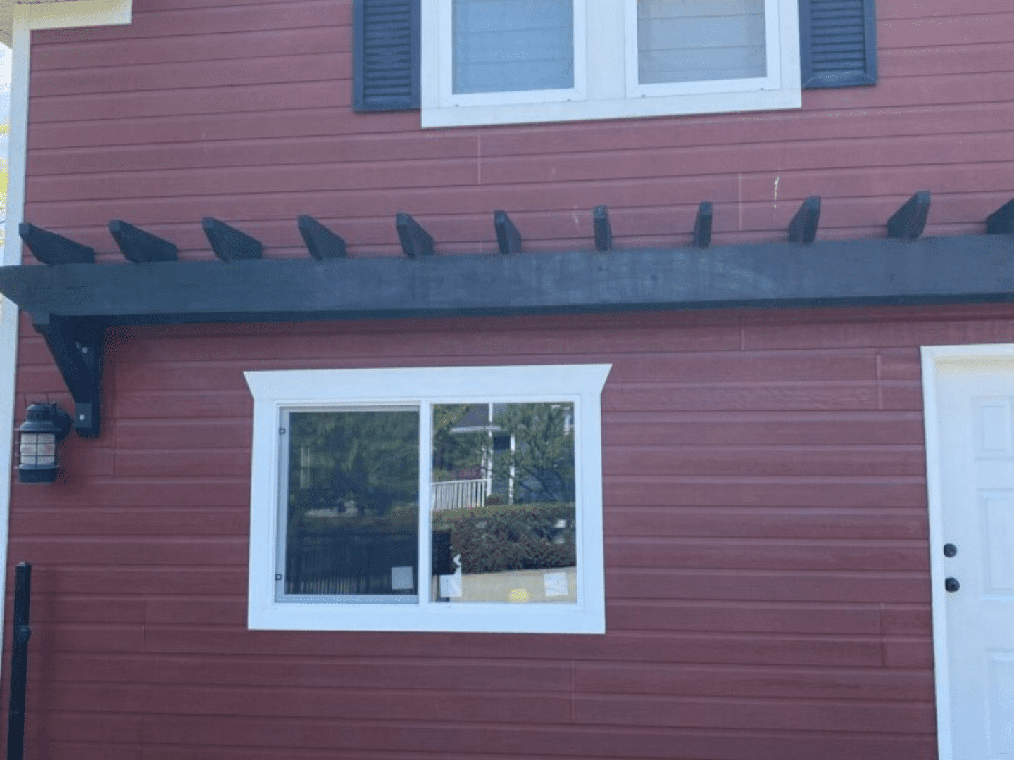 A red house with a window and some birds on the roof